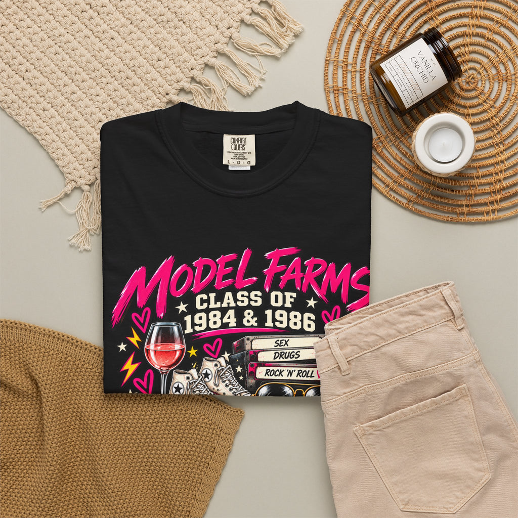 Black crewneck T-shirt with colorful retro class graphic, styled flat lay
