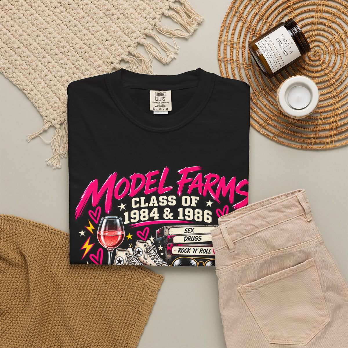 Black crewneck T-shirt with colorful retro class graphic, styled flat lay