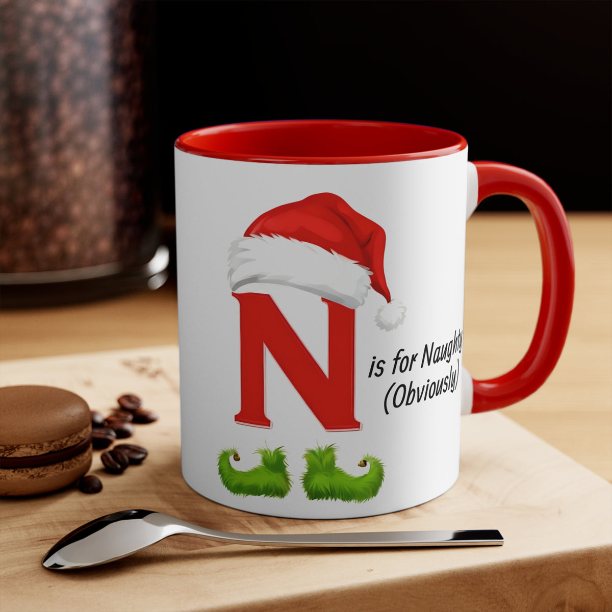 Red-handled ceramic mug with red letter N, Santa hat, green mustache, “is for Naughty” text.
