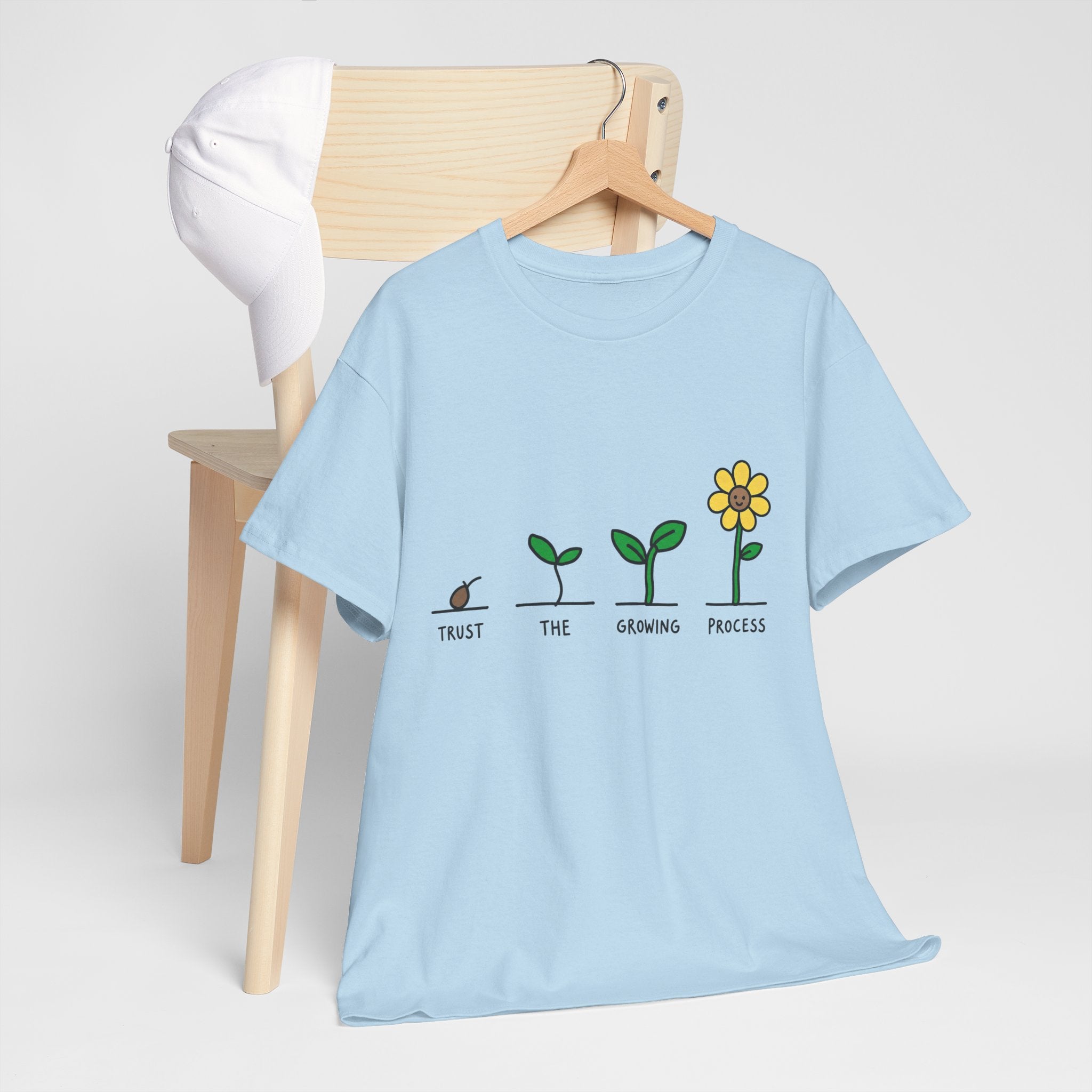 Light blue crewneck T-shirt with seedling-to-flower graphic and small slogan text
