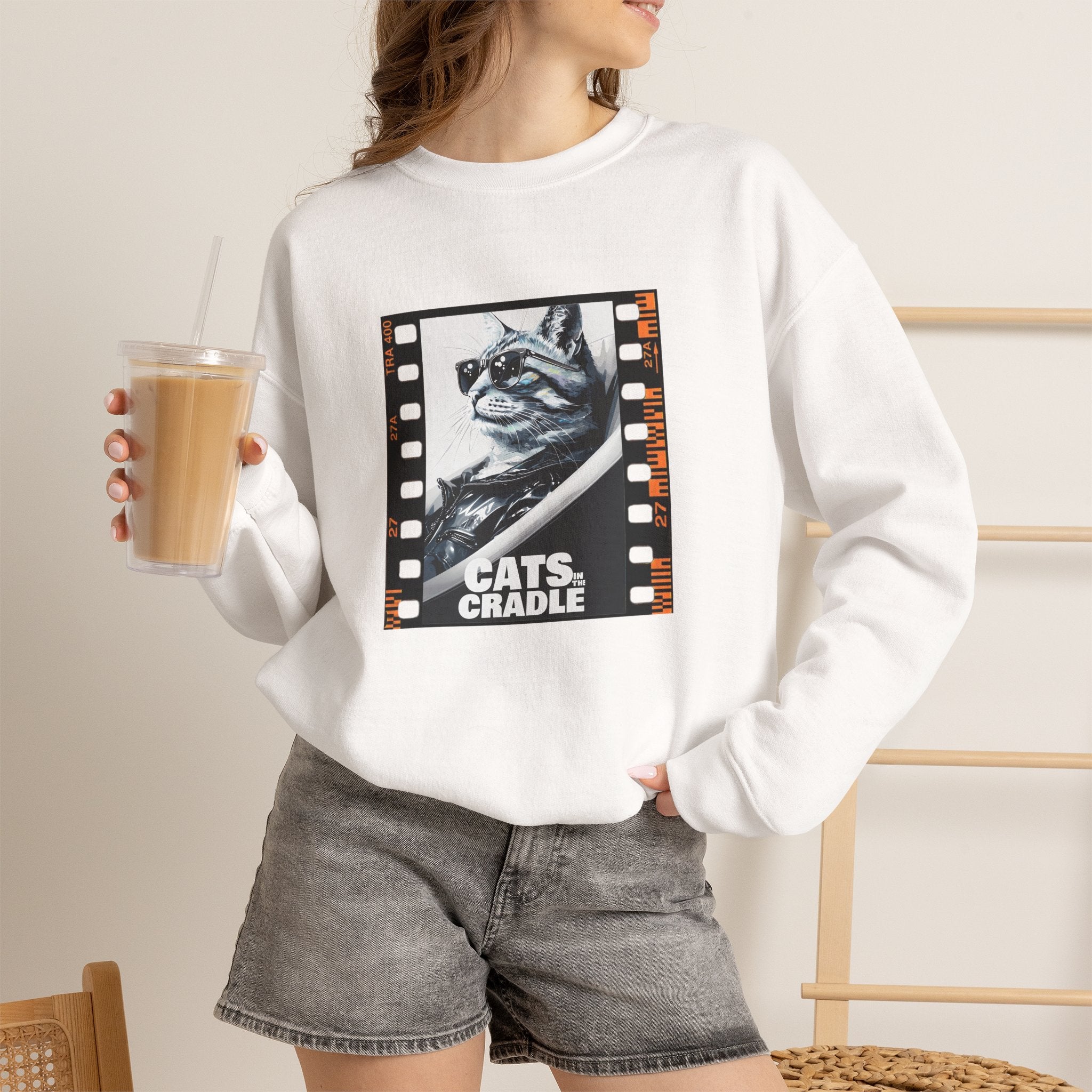 White crewneck sweatshirt worn by model, cat film-strip graphic on chest