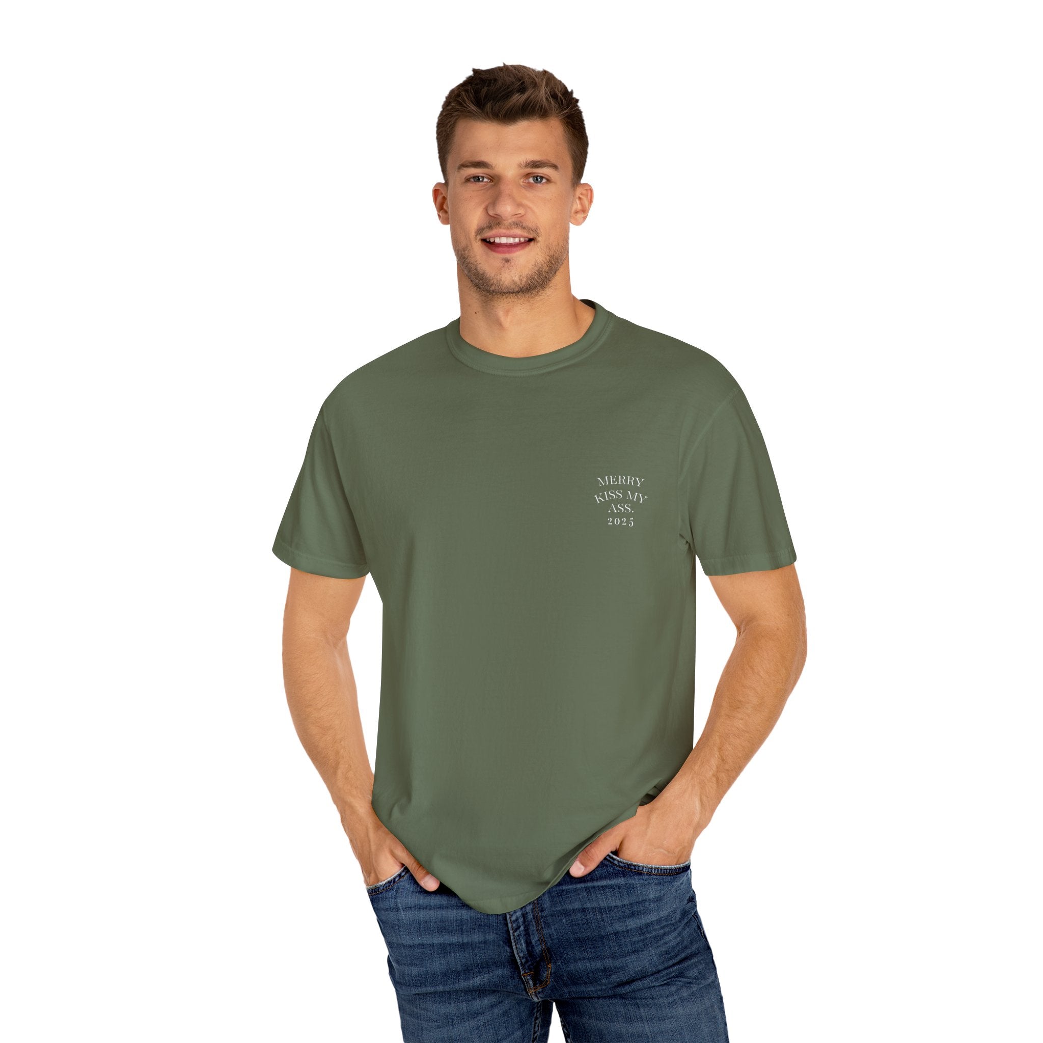 Sage green unisex T-shirt with small chest text “MERRY KISS MY ASS. 2025”