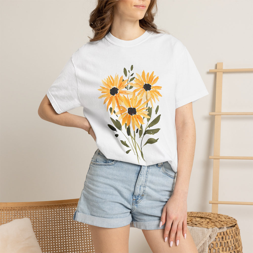 White t-shirt on model with sunflower bouquet graphic in orange and black at the chest