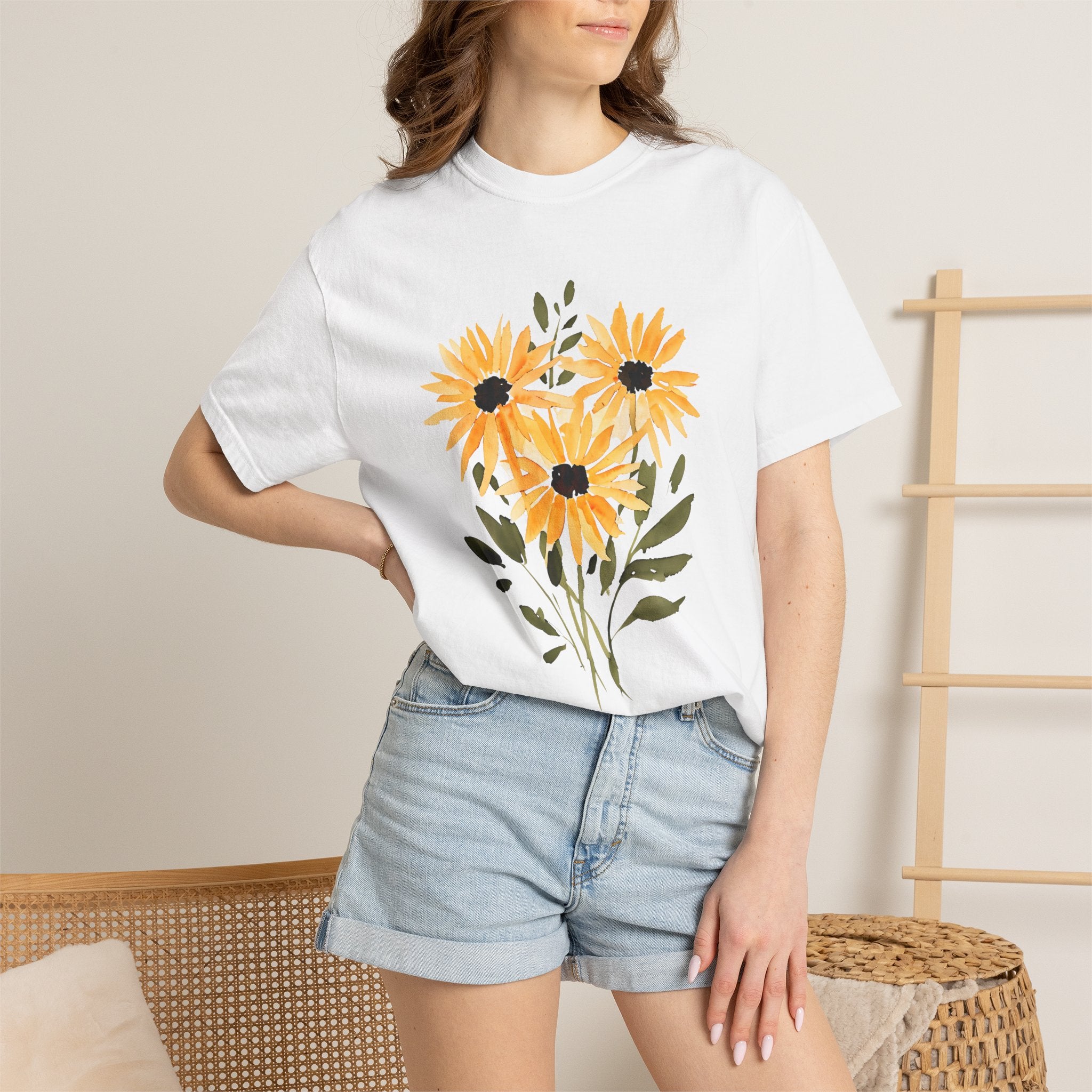 White t-shirt on model with sunflower bouquet graphic in orange and black at the chest