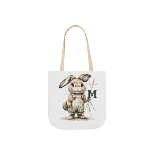 Canvas tote bag with rabbit holding letter M, beige handles, off-white bag.