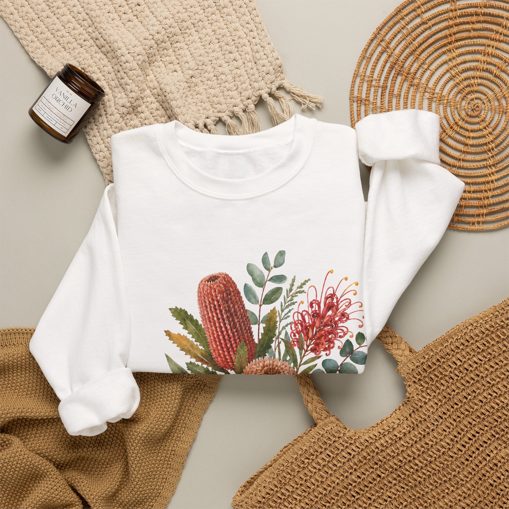 White crewneck sweatshirt with wildflower graphic, long sleeves and cuffs visible