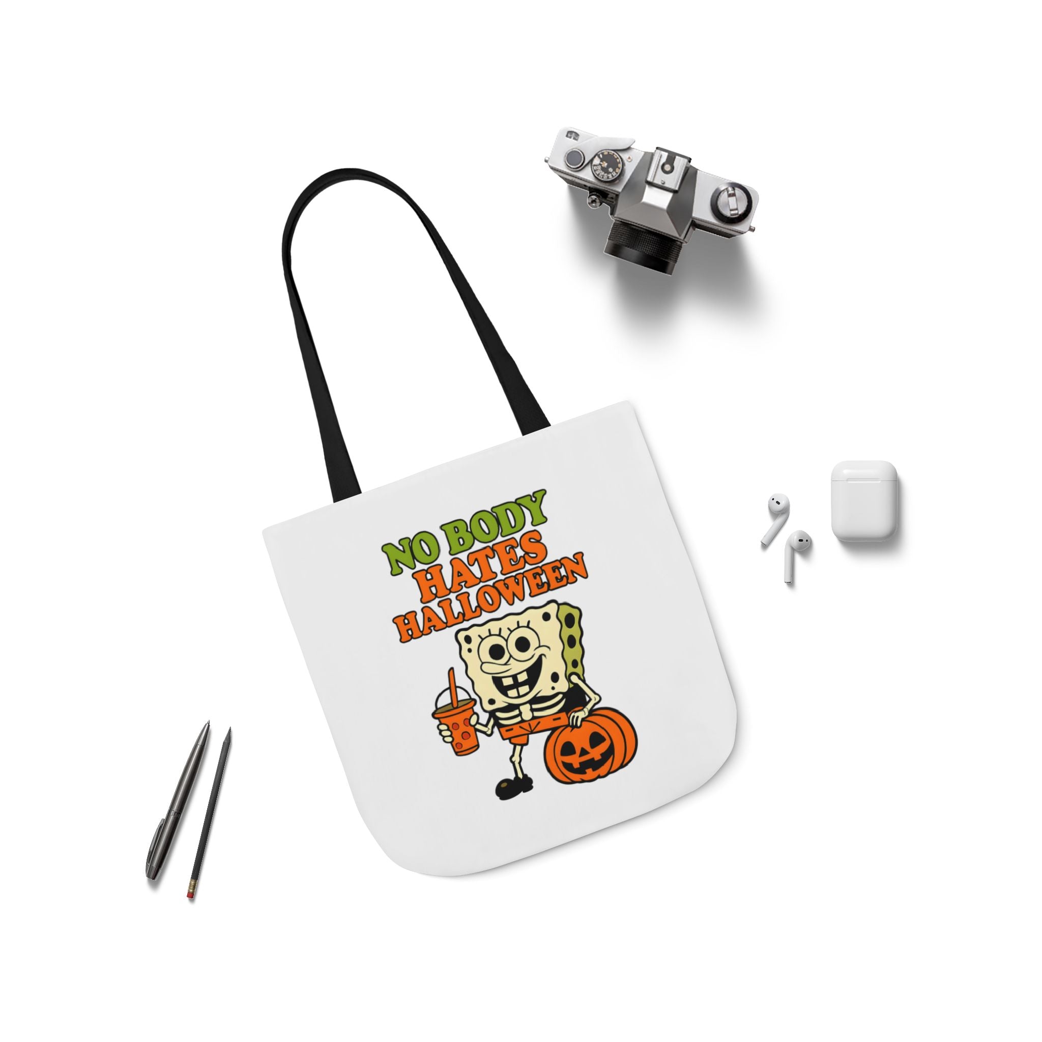 White canvas tote bag with black handles, front slogan and cartoon character illustration
