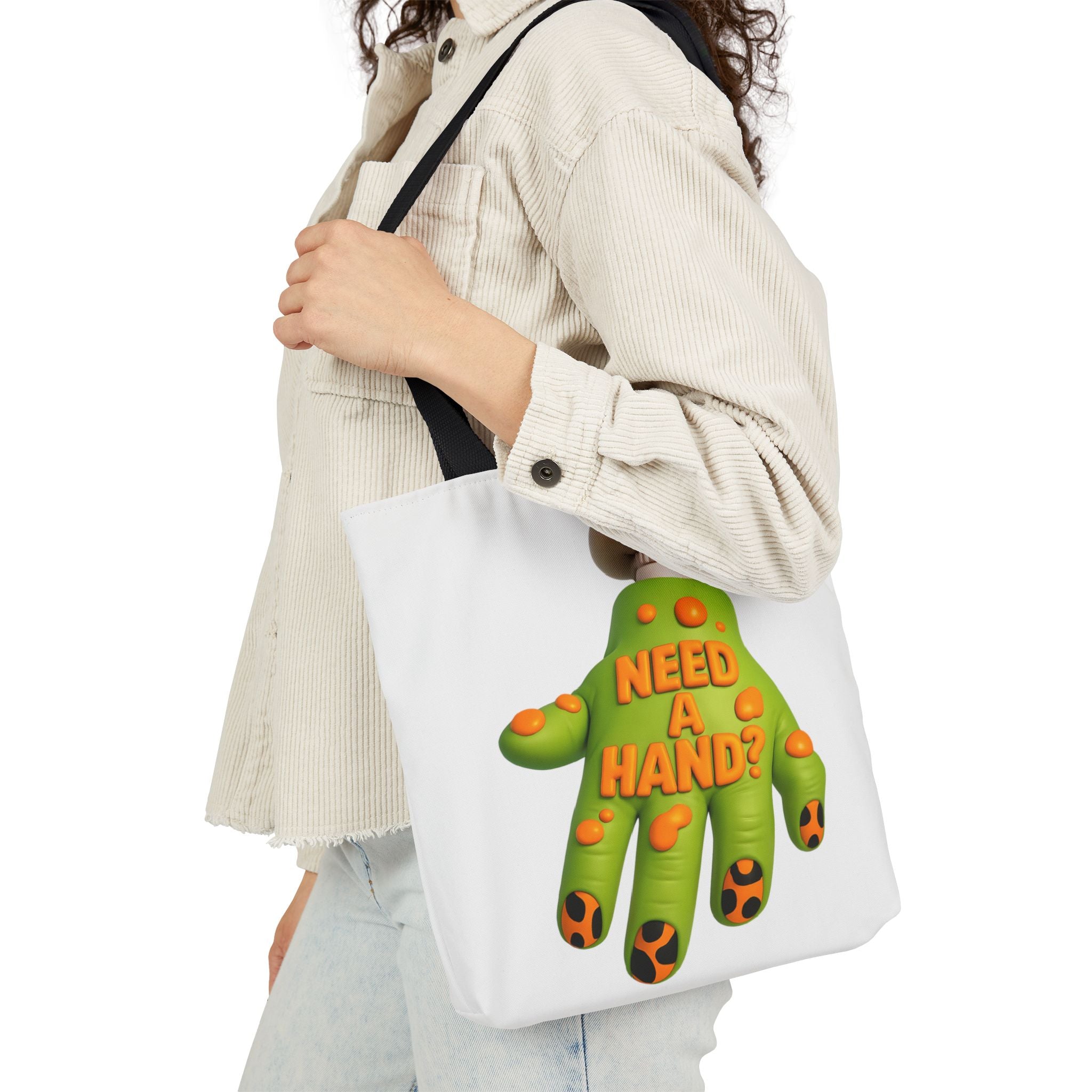 White canvas tote bag with black handles and green "Need A Hand" hand graphic.