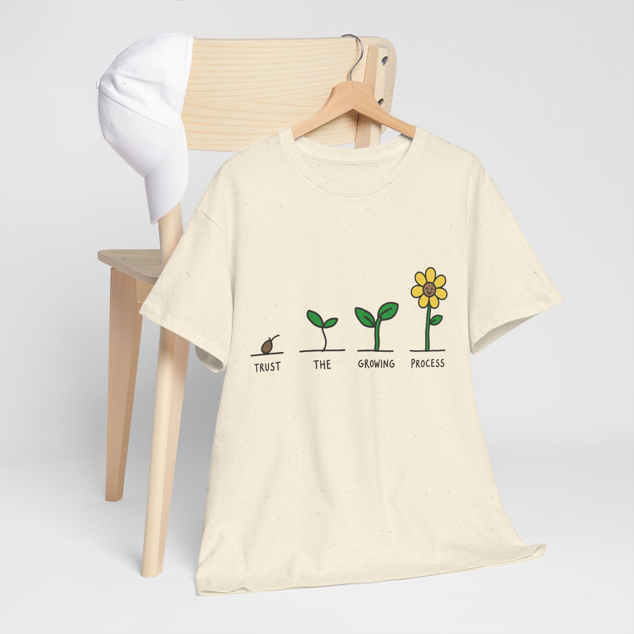 Natural/off-white crewneck T-shirt with green seedling-to-flower graphic and yellow blossom