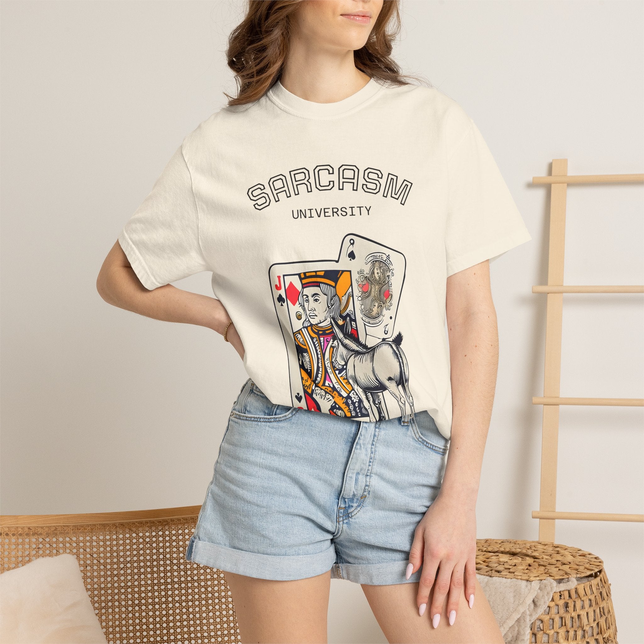 Ivory unisex T-shirt with “SARCASM UNIVERSITY” text and playing-card unicorn graphic