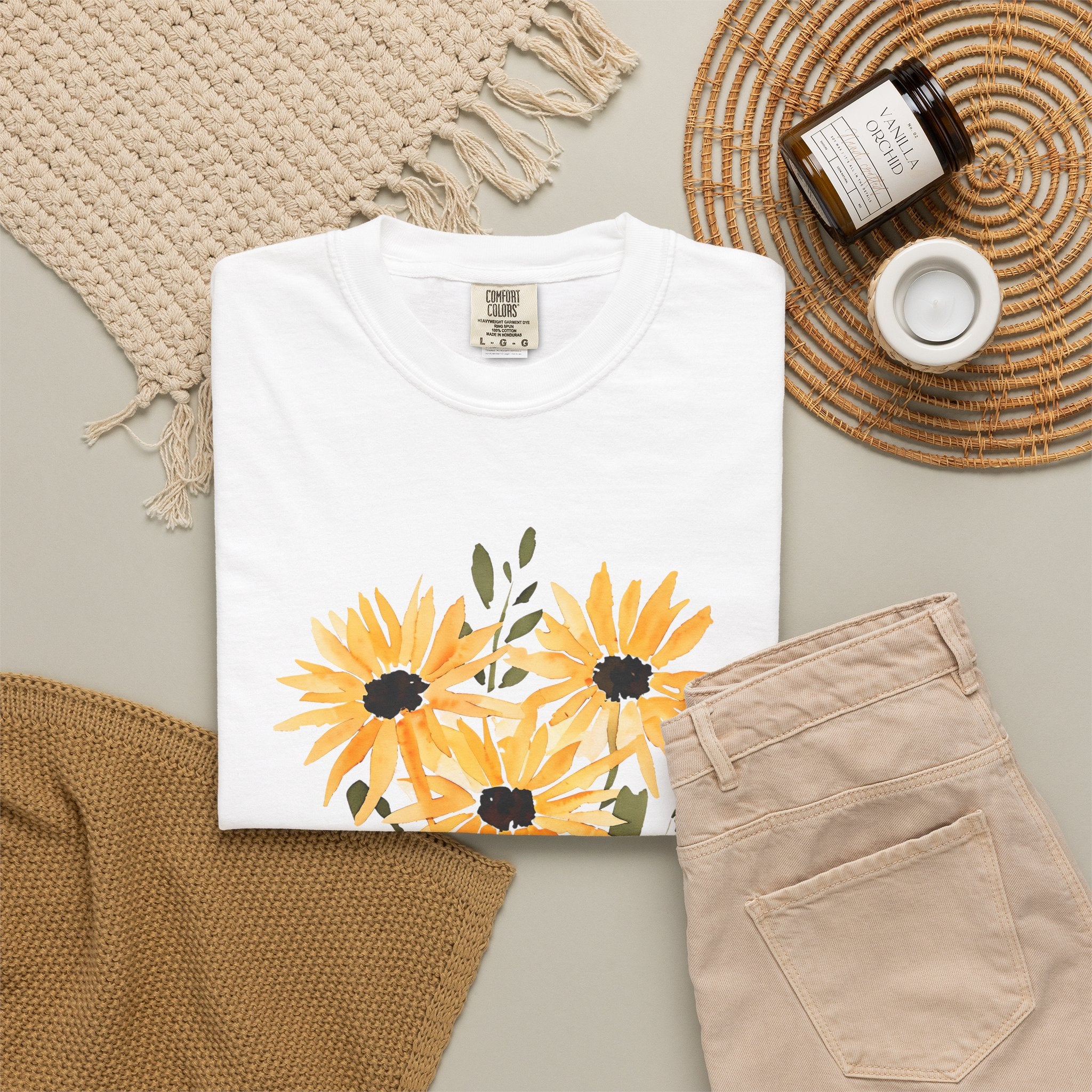 White crew-neck T-shirt with large orange sunflower bouquet print and green leaves