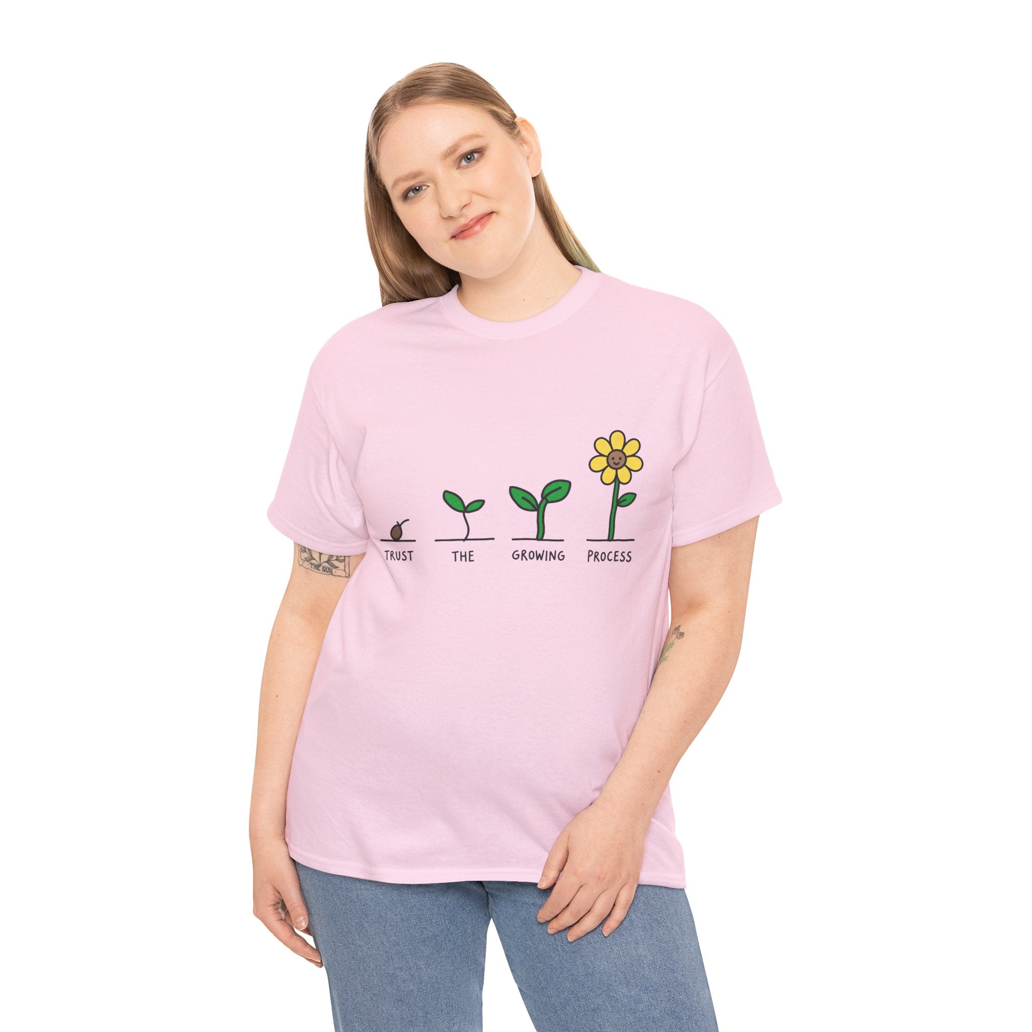 Pink crewneck T-shirt on model, seedling-to-flower graphic with yellow blossom