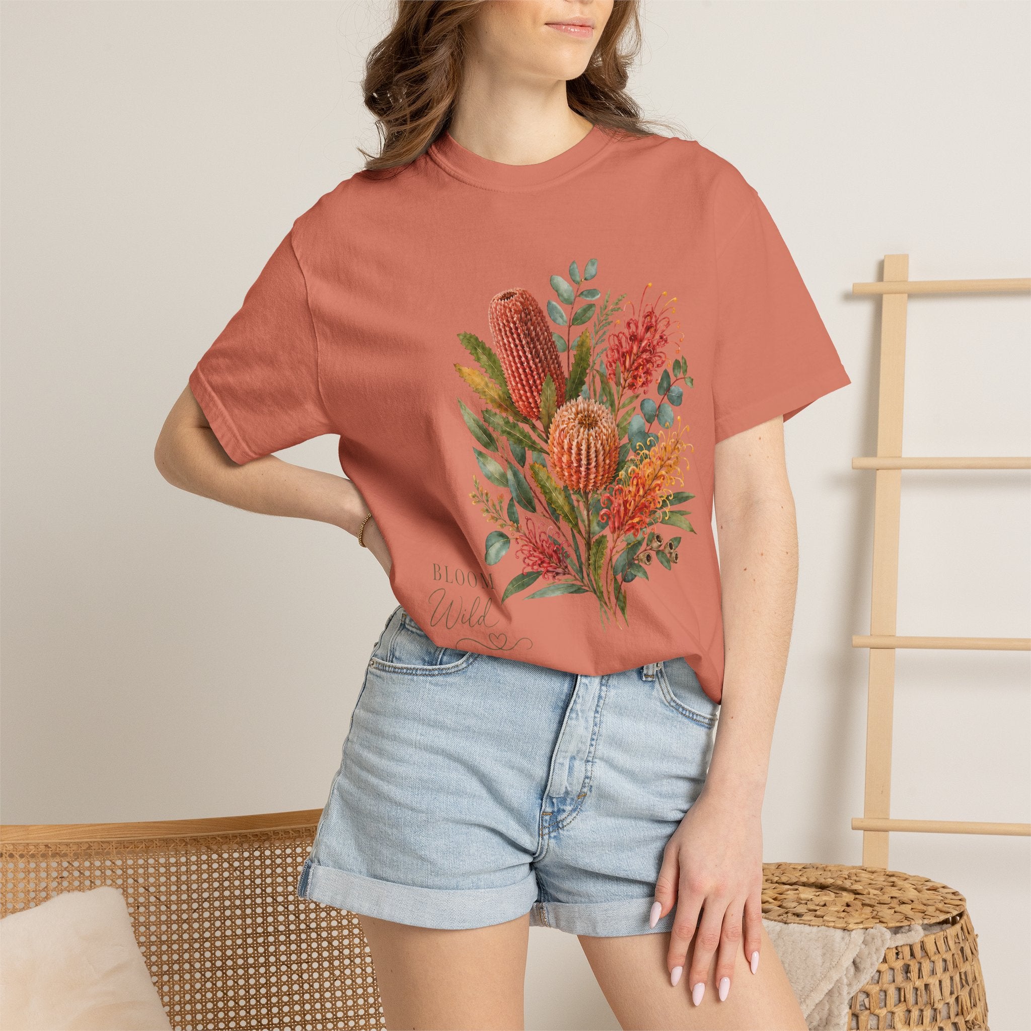 Terracotta crew-neck t-shirt with colorful botanical protea bouquet graphic at center