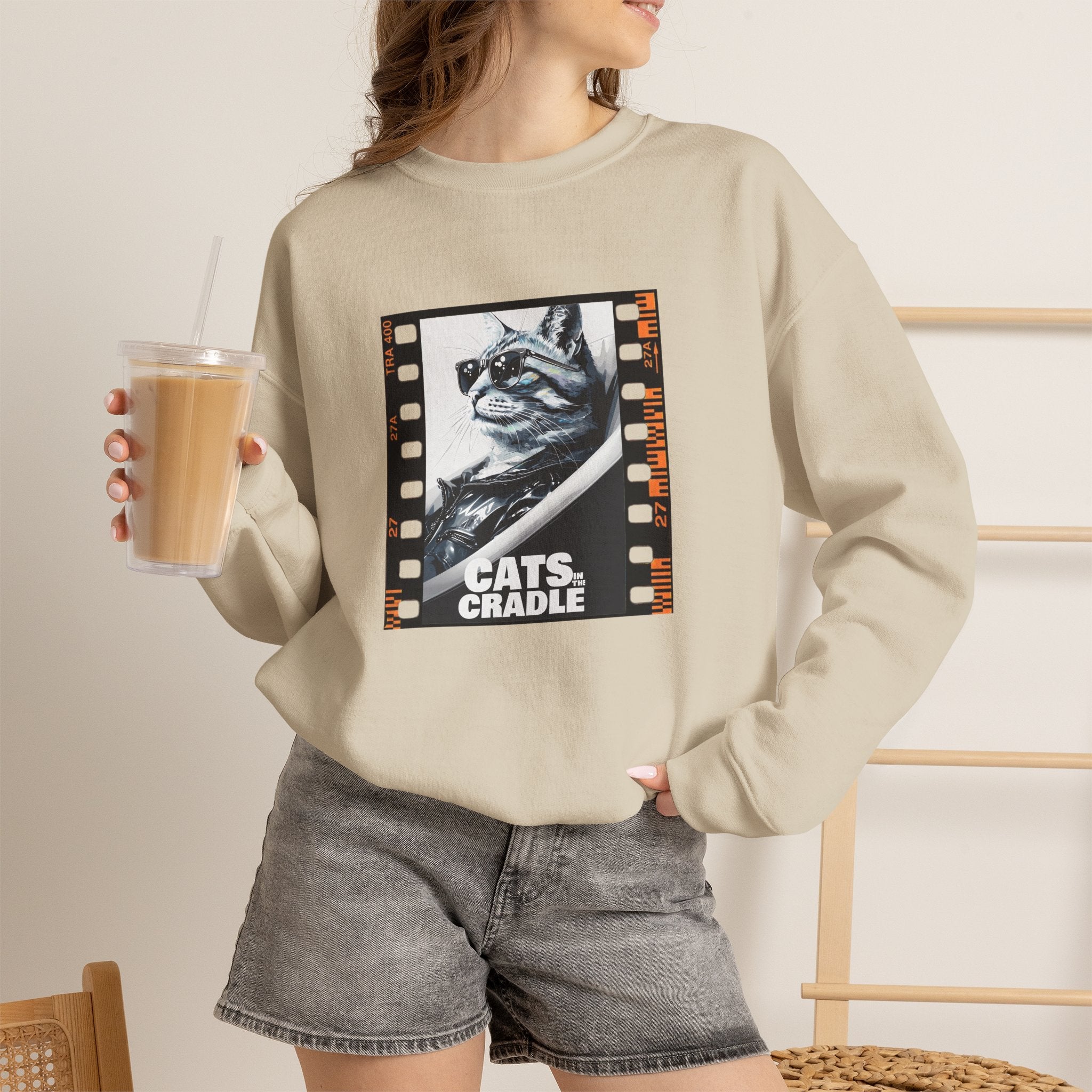Beige crewneck sweatshirt worn by model, cat film-strip graphic on chest
