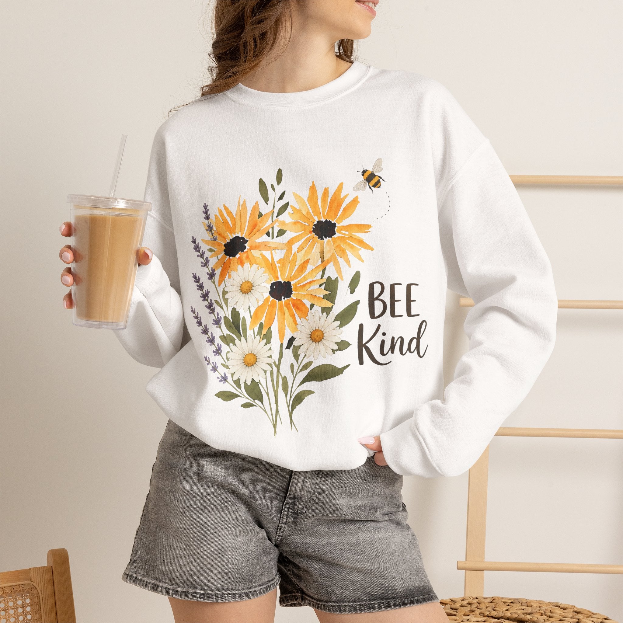 White crewneck sweatshirt with sunflower bouquet art, bee, and 'Bee Kind' wording.