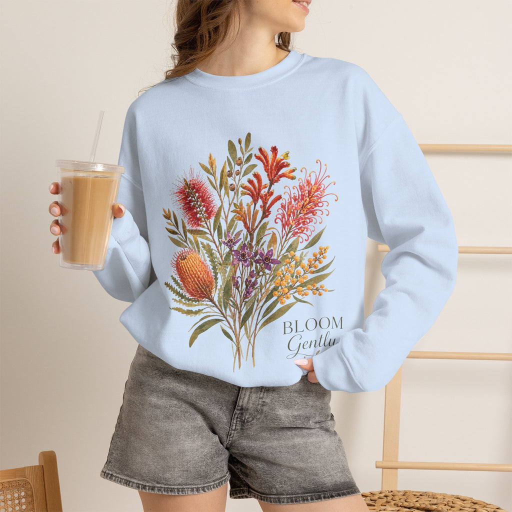 Light blue crewneck sweatshirt with floral bouquet print and "Bloom Gently" text