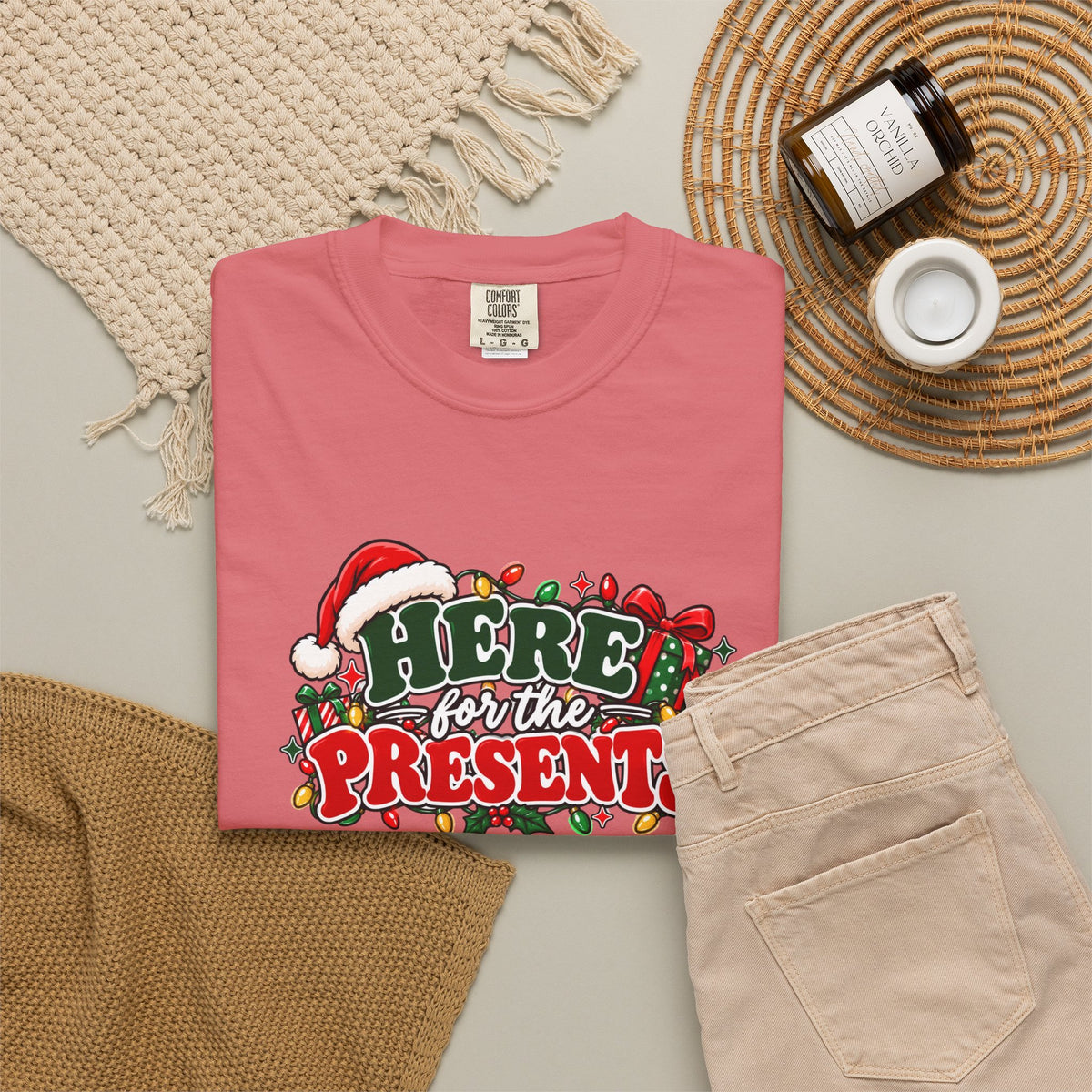 Red graphic Christmas T-shirt folded, “Here for the Presents” logo on front