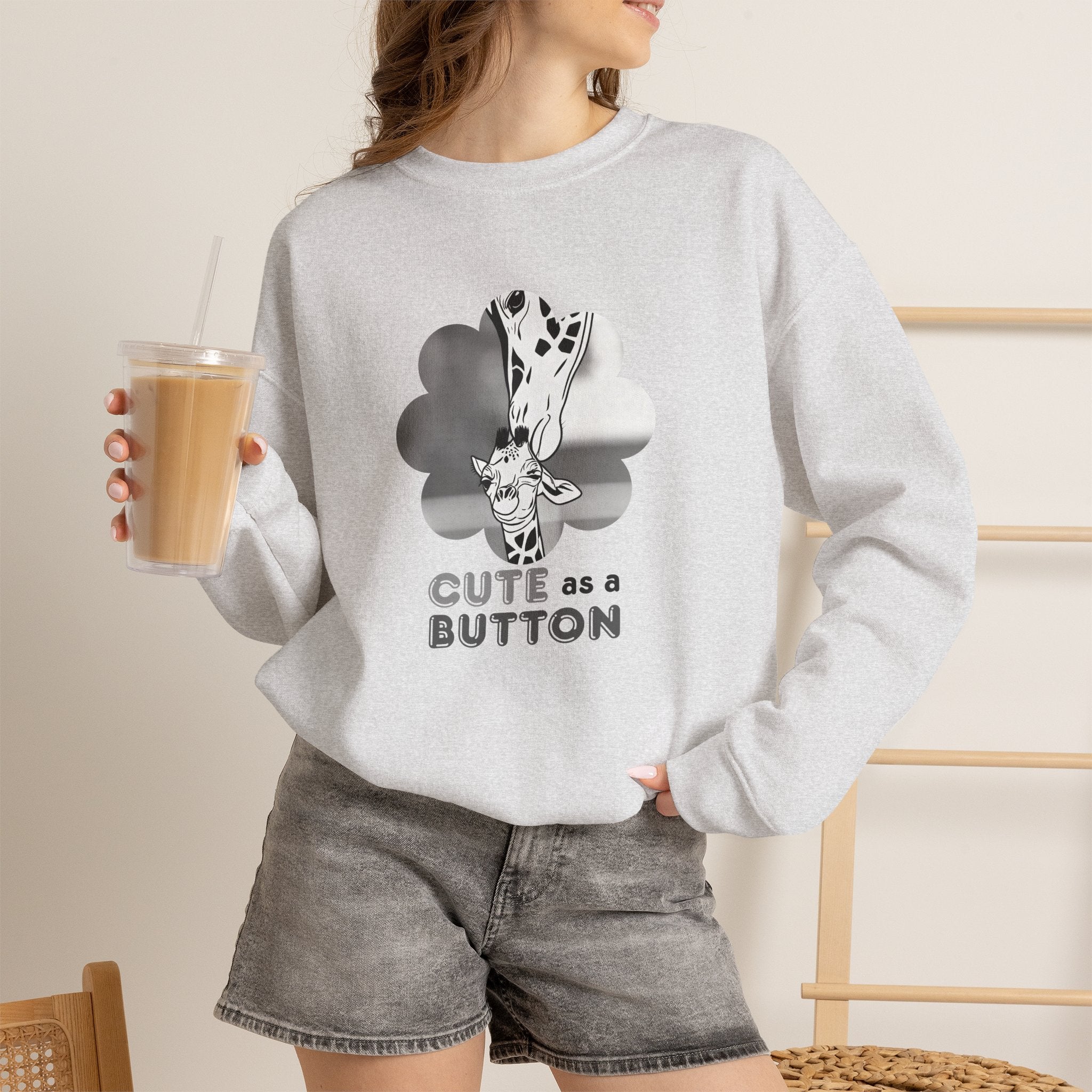 Heather gray crewneck sweatshirt with giraffe cloud graphic and "CUTE as a BUTTON" text