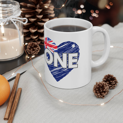 White ceramic coffee mug with blue heart graphic and the word ONE