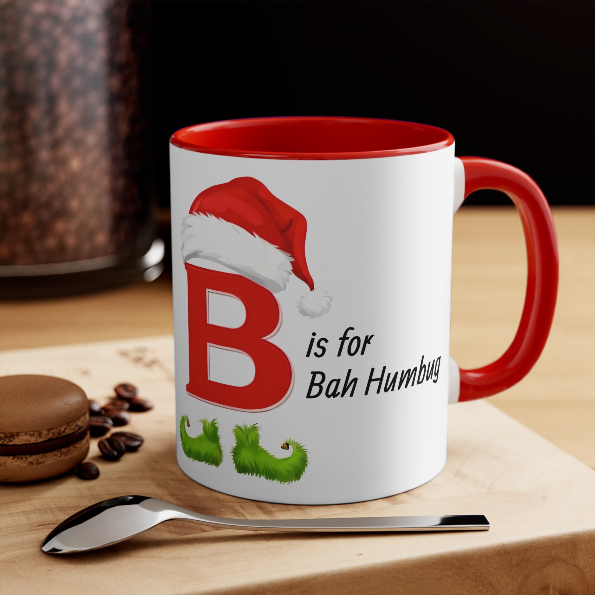 White Christmas coffee mug with red rim and handle; “B is for Bah Humbug” design with Santa hat