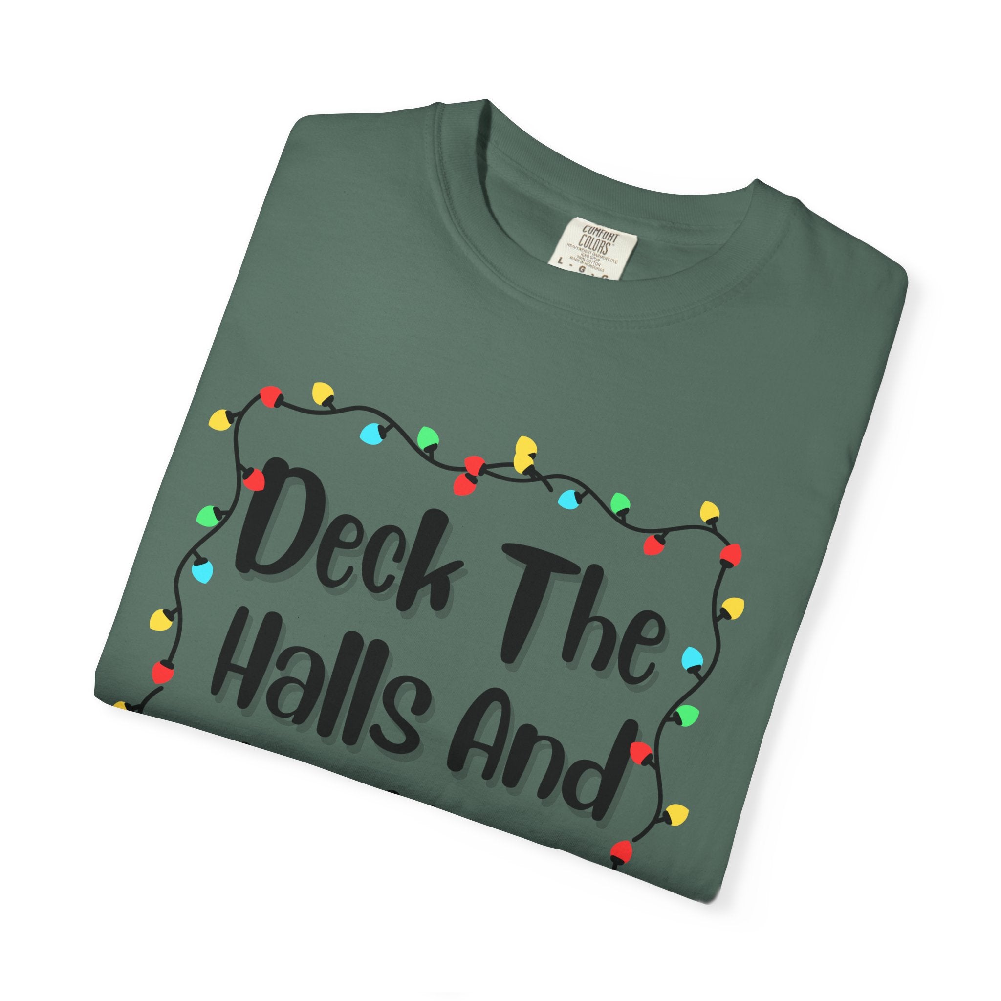 Folded sage green T-shirt with 'Deck The Halls And Not Your Sibling' lights graphic