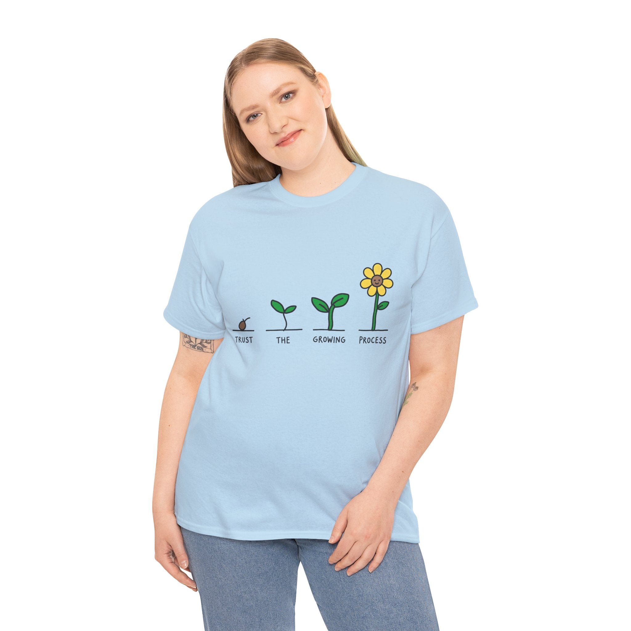 Light blue crewneck T-shirt on model, seedling-to-flower graphic with yellow blossom
