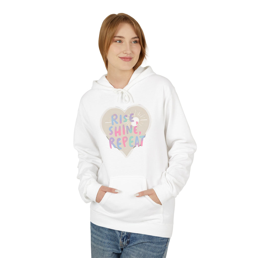 White hoodie with front pocket, drawstring hood, and heart "Rise Shine Repeat" graphic
