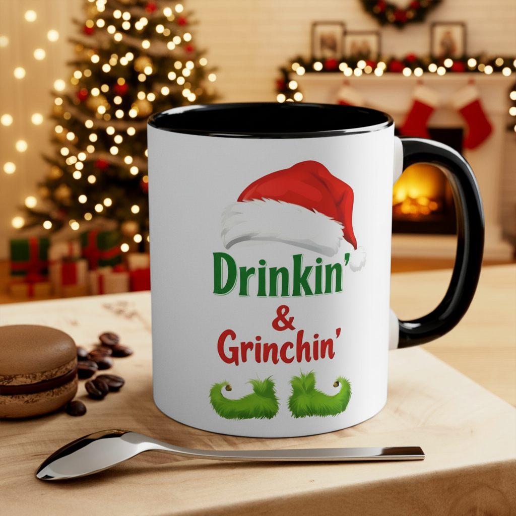 Holiday coffee mug with black handle and rim, white body, 'Drinkin' & Grinchin'' design