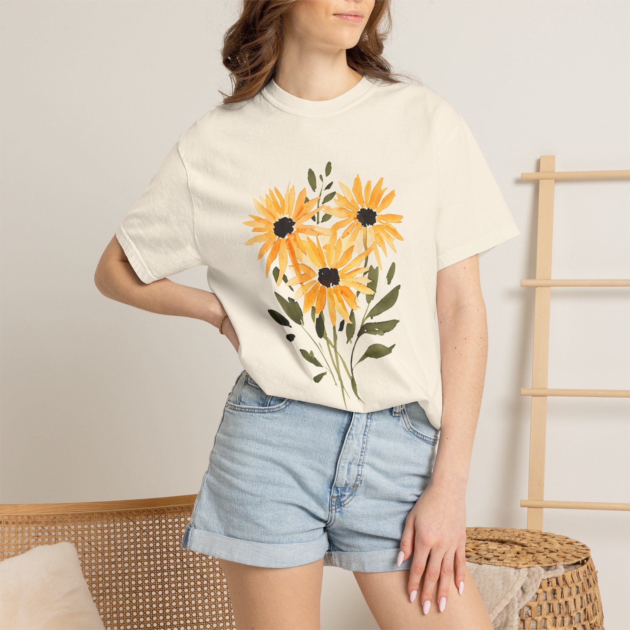 White crew-neck T-shirt with orange sunflower bouquet graphic, worn with light denim shorts