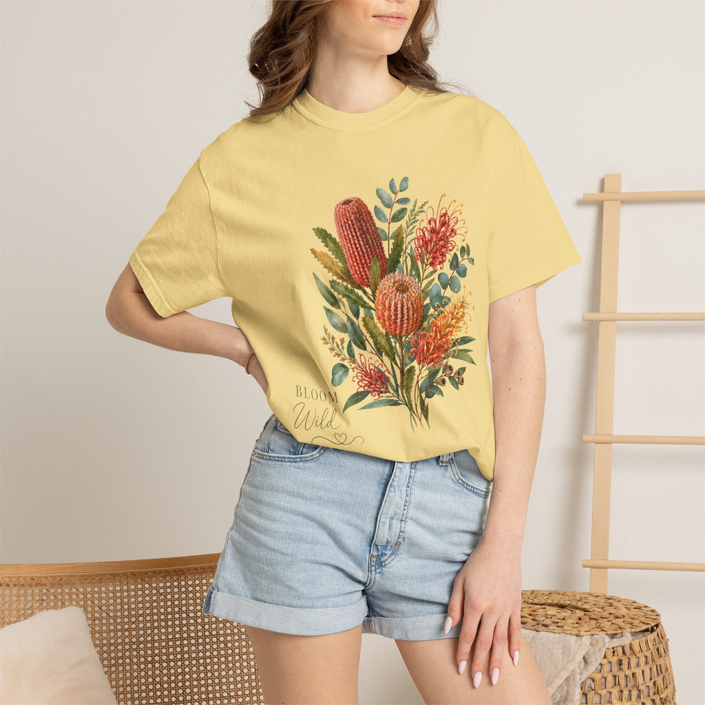 Model wearing a butter T-shirt with a protea bouquet graphic and leafy accents