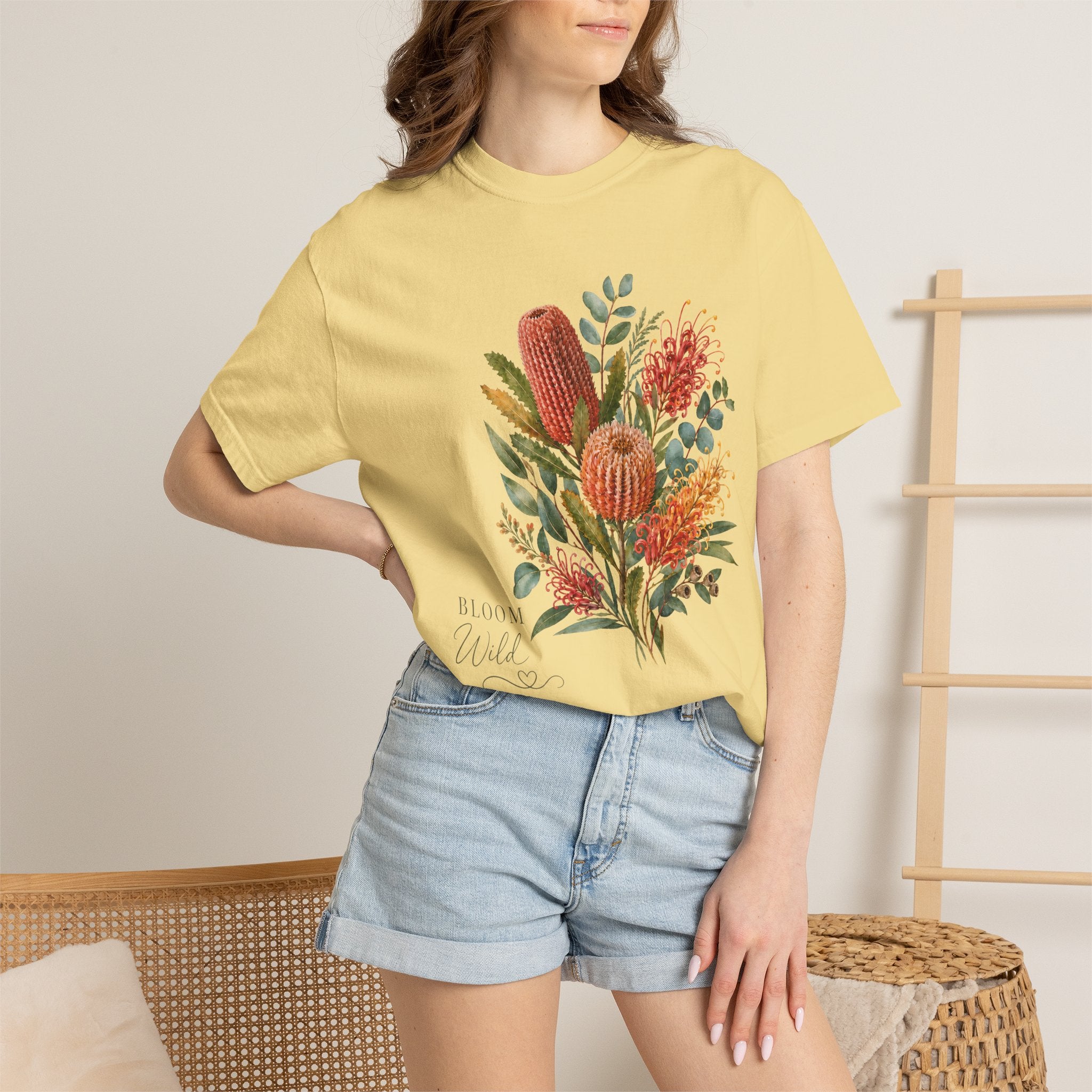 Model wearing a butter T-shirt with a protea bouquet graphic and leafy accents