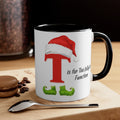 Black-and-white mug with red Santa-hat letter T and green jolly trim, printed quote