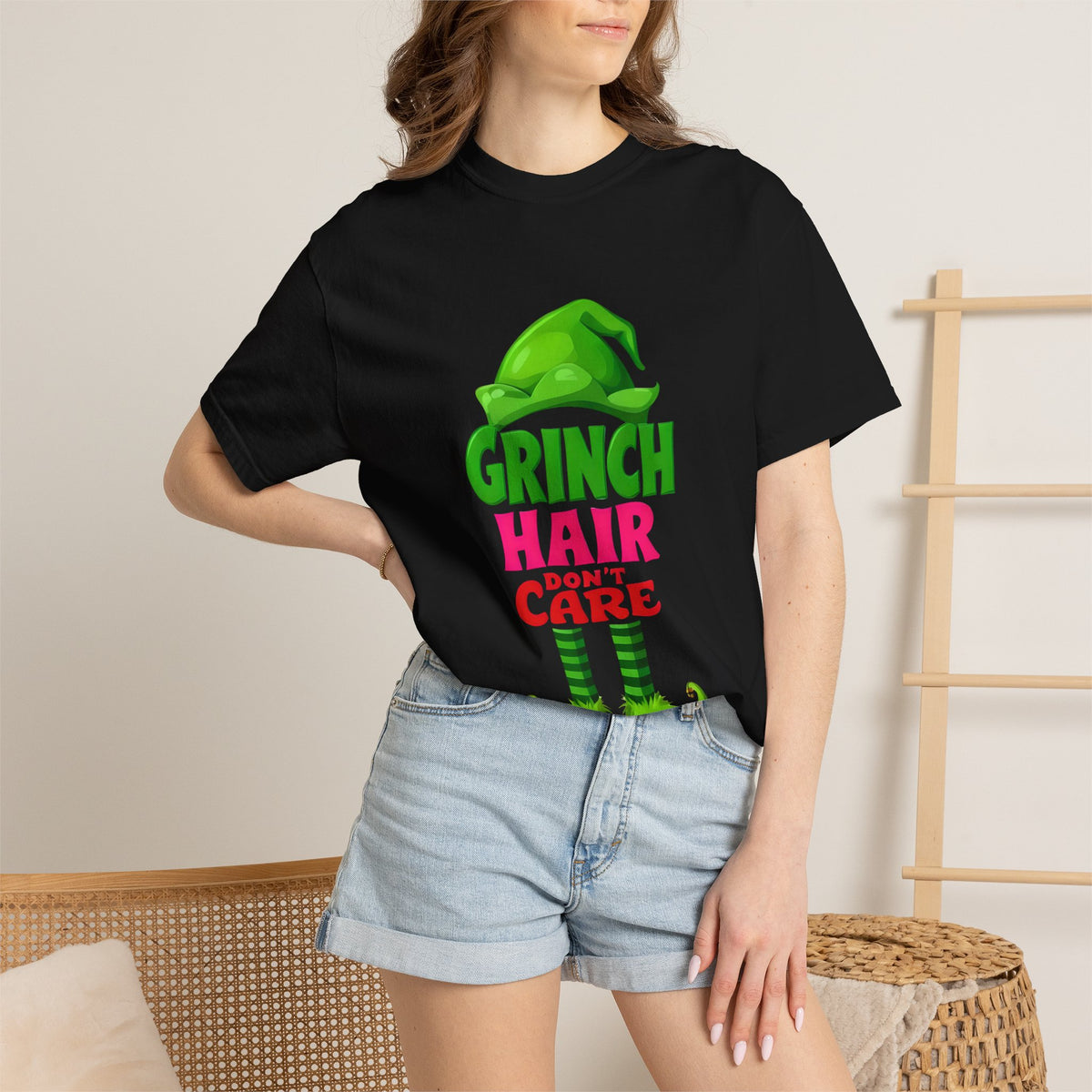 Black graphic T-shirt with Grinch Hair Care front print on woman