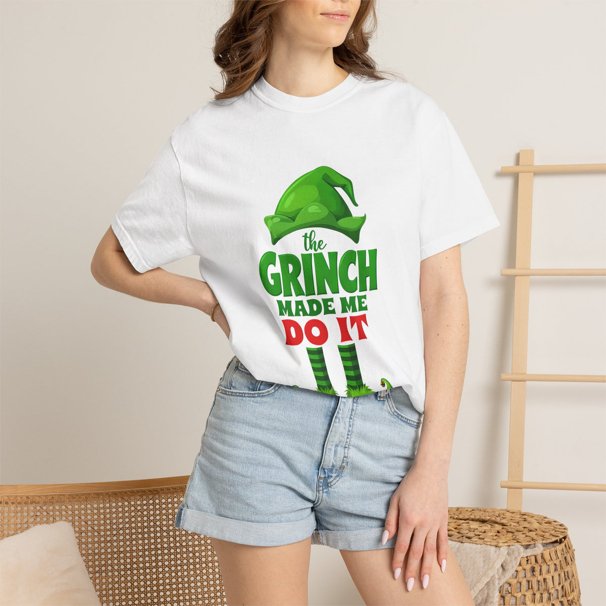 White unisex T-shirt worn by model with green Grinch “the GRINCH made me do it” print