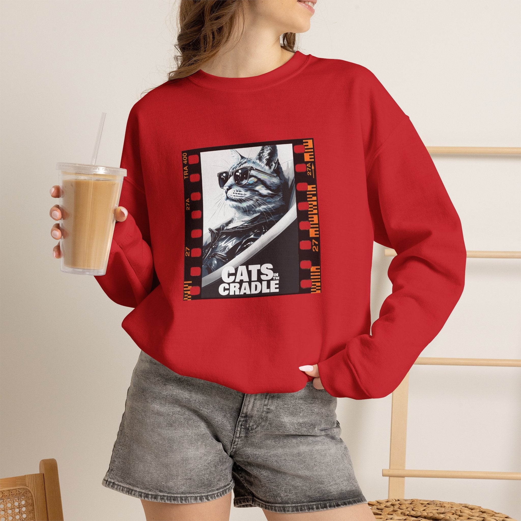 Red crewneck sweatshirt with cat graphic front, worn with gray shorts