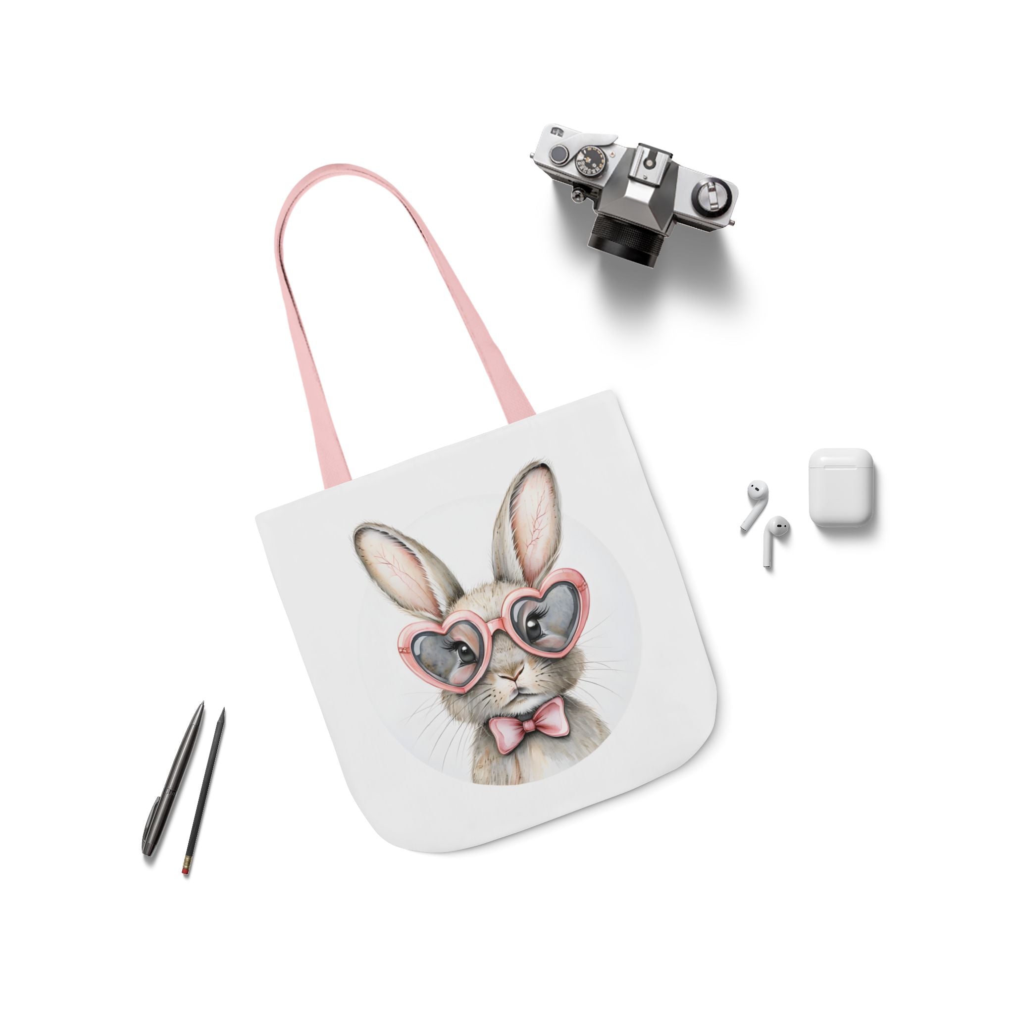 Canvas tote bag with bunny face print, light pink strap, and small accessory items shown