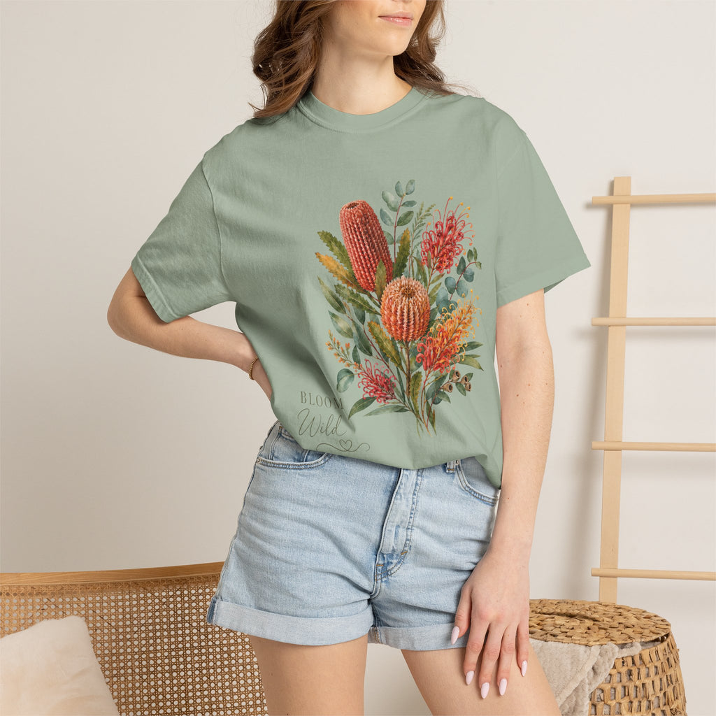Model wearing a sage green T-shirt with a colorful protea floral bouquet design