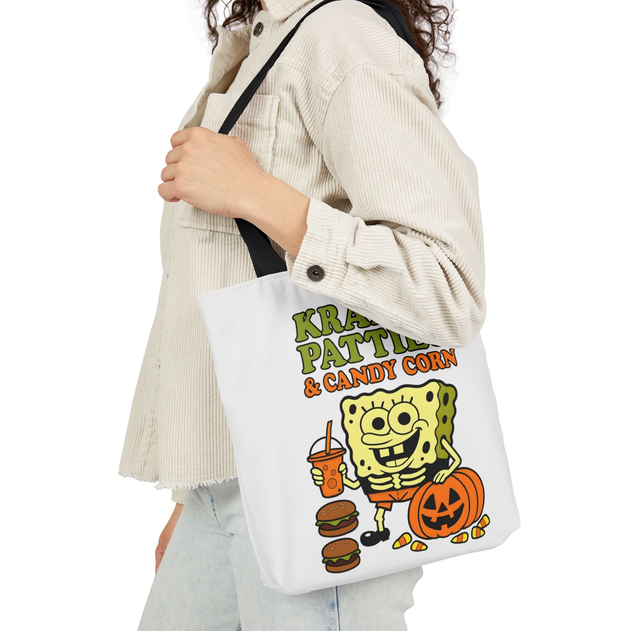 Canvas tote bag with black handles, white body, and colorful Krabby Patties & candy corn print