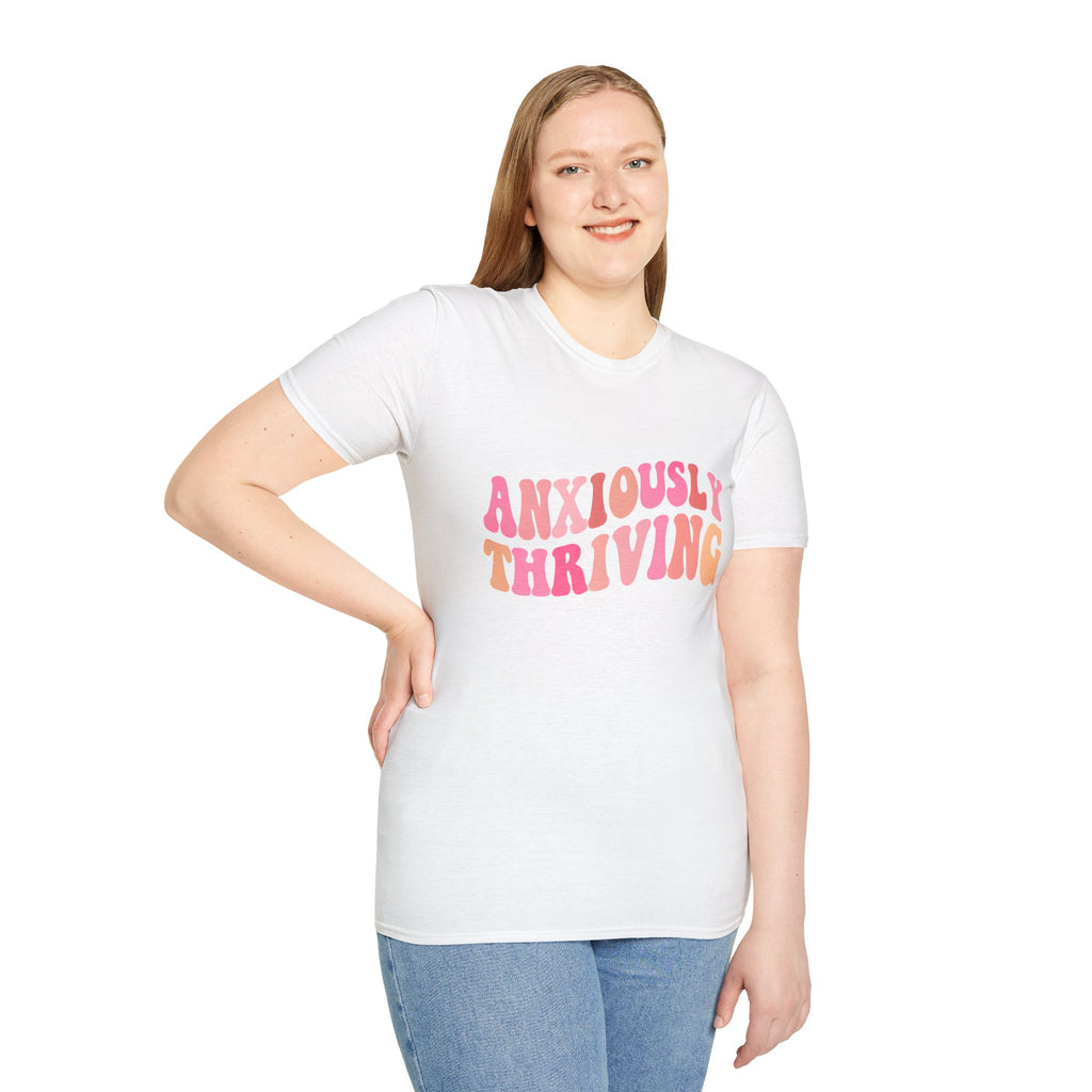 Unisex softstyle t-shirt in white with “ANXIOUSLY THRIVING” graphic on chest