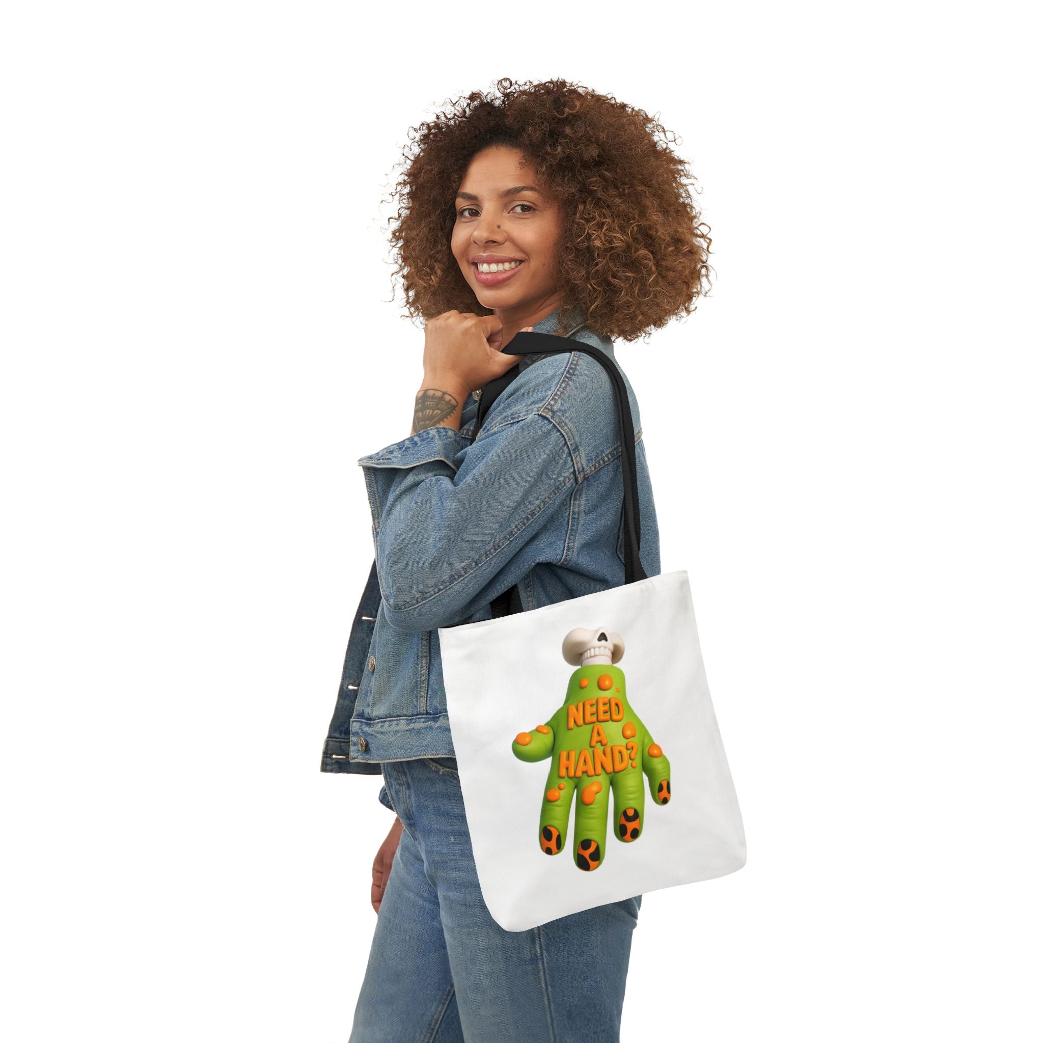White canvas tote bag with black handles featuring a colorful "Need A Hand" print.