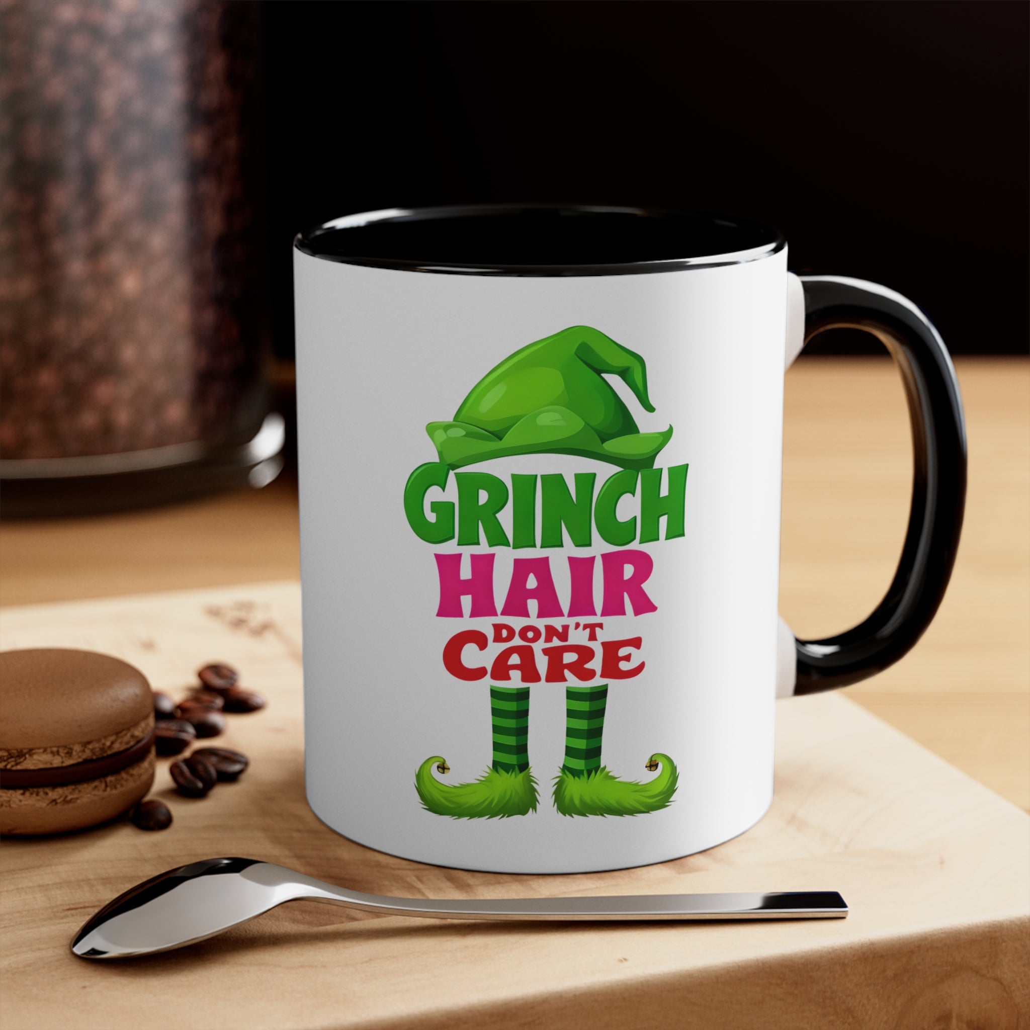 White ceramic accent mug with green Grinch Hair Don't Care graphic, black handle and rim.
