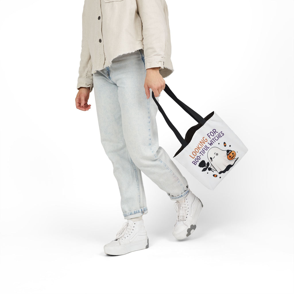 White canvas tote bag with black handles; ghost with jack-o'-lantern and orange text
