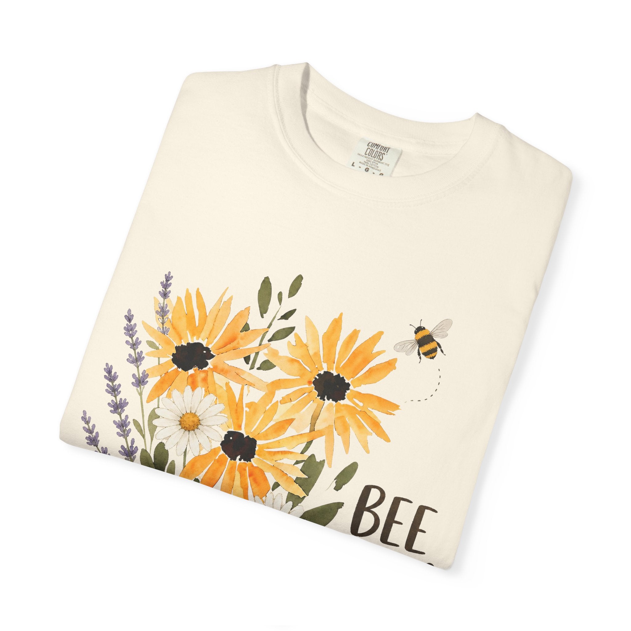 Cream t-shirt close-up with sunflower and lavender bouquet graphic and 'Bee Kind' text