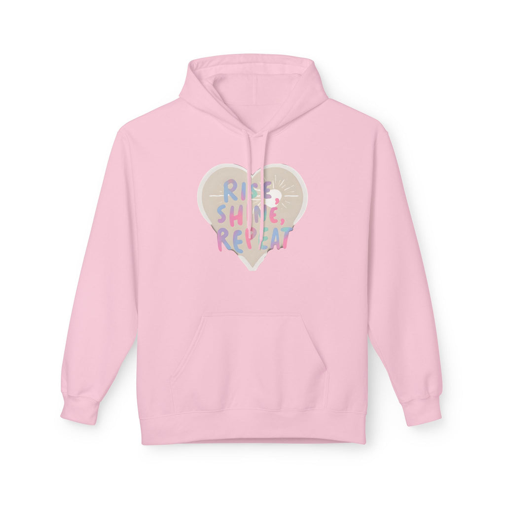 Light pink hoodie with drawstring hood, front pocket, and heart "Rise Shine Repeat" graphic
