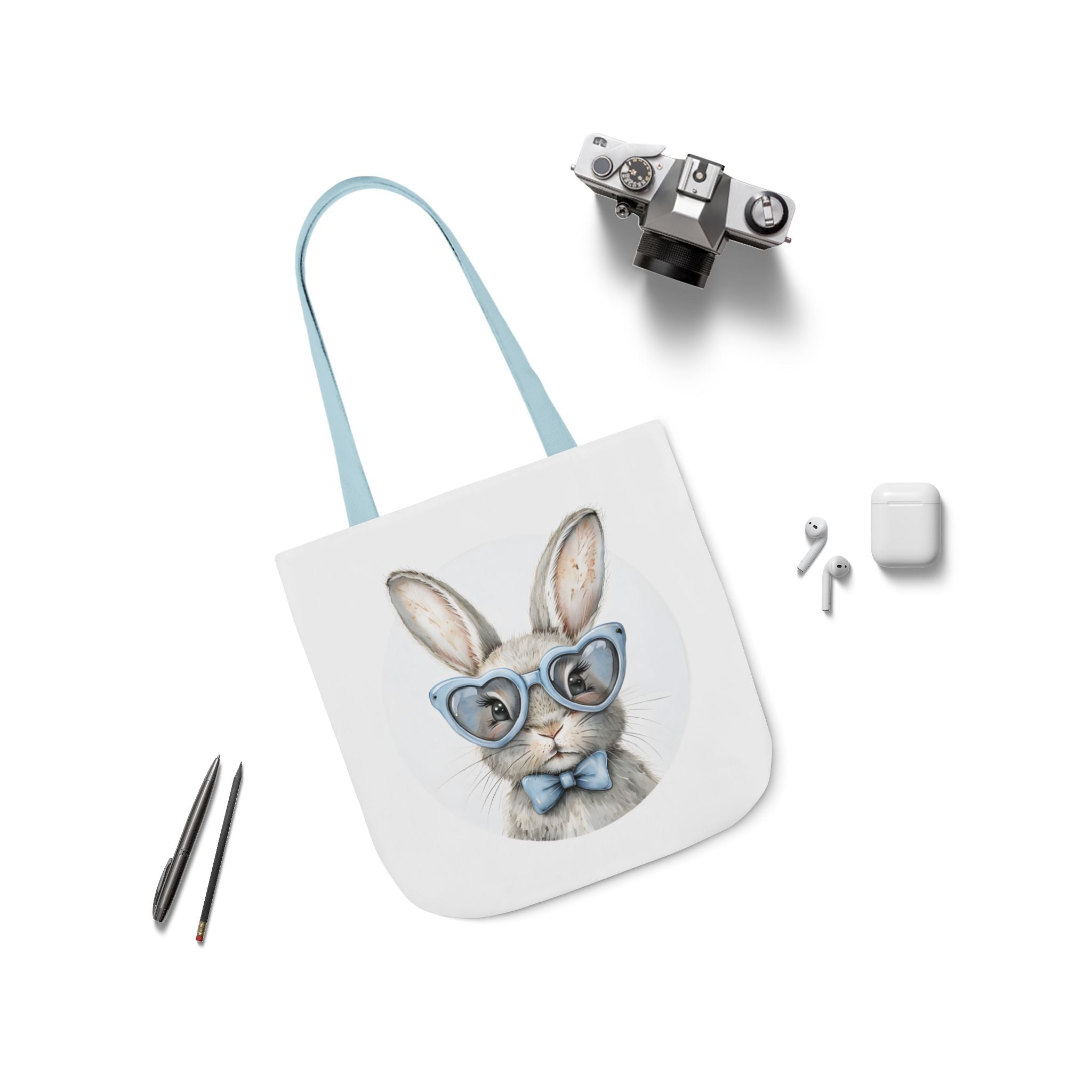 Bunny canvas tote bag with rabbit face graphic, light blue straps laid flat