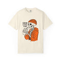 Ivory graphic tee with Grim & Tonic Time skull in orange jacket holding a drink