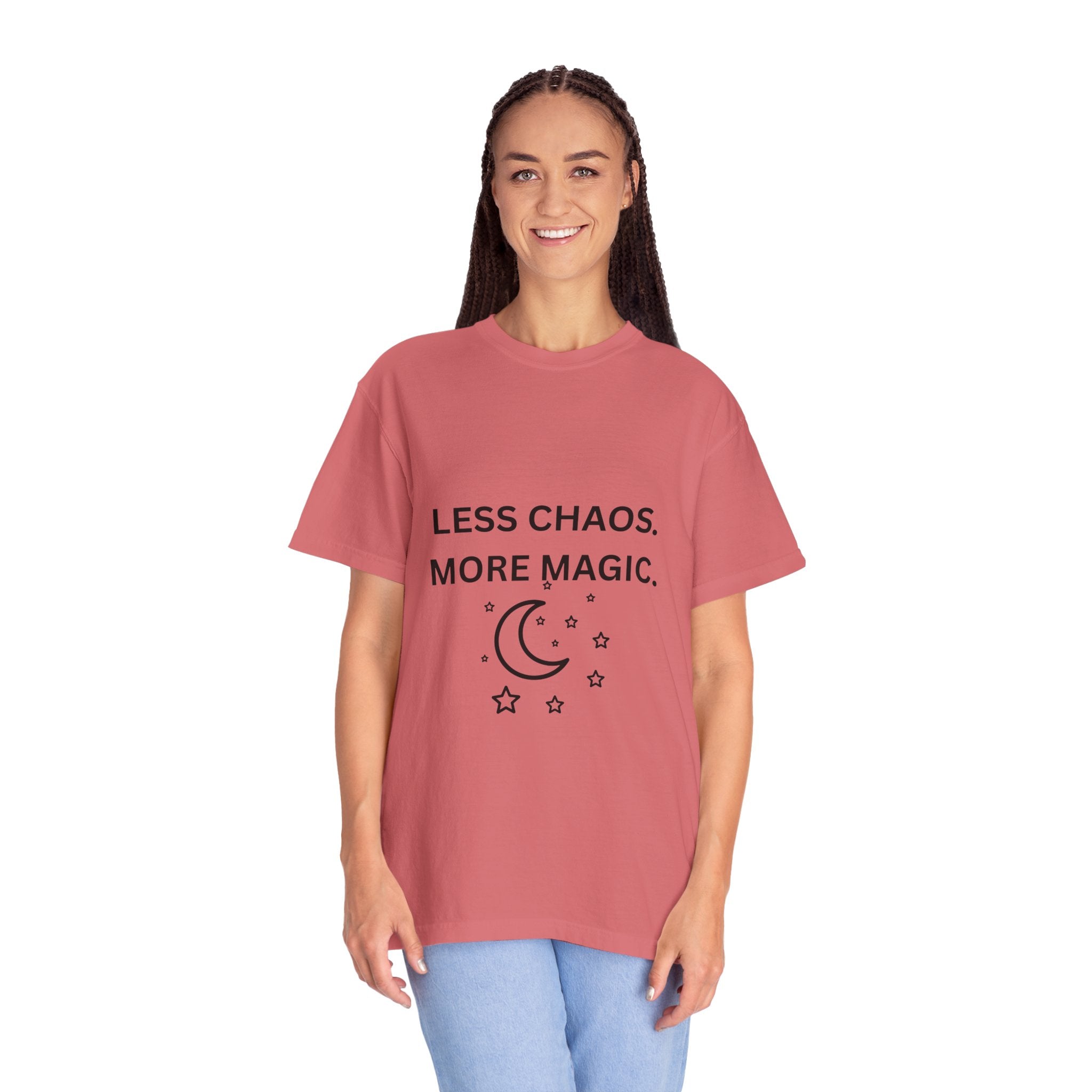 Pink crewneck T-shirt worn by a woman; “Less Chaos, More Magic” with moon and stars