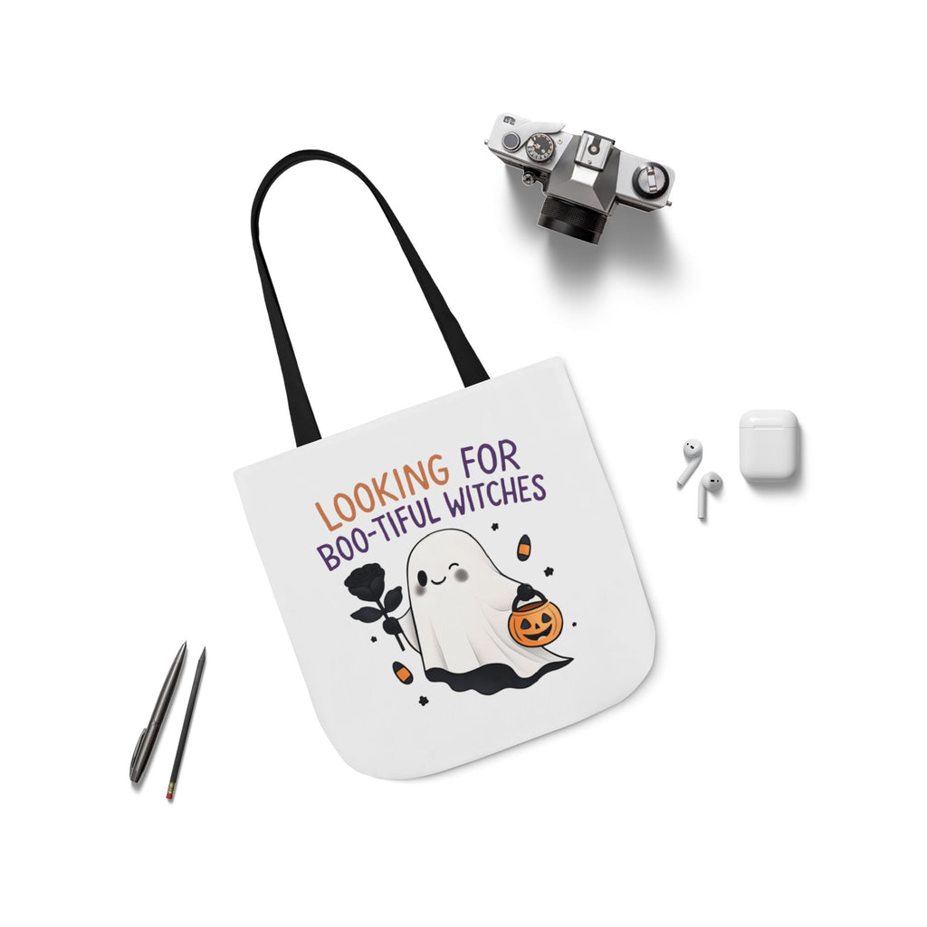 Flat-lay white canvas tote bag with black handles; ghost and pumpkin front design