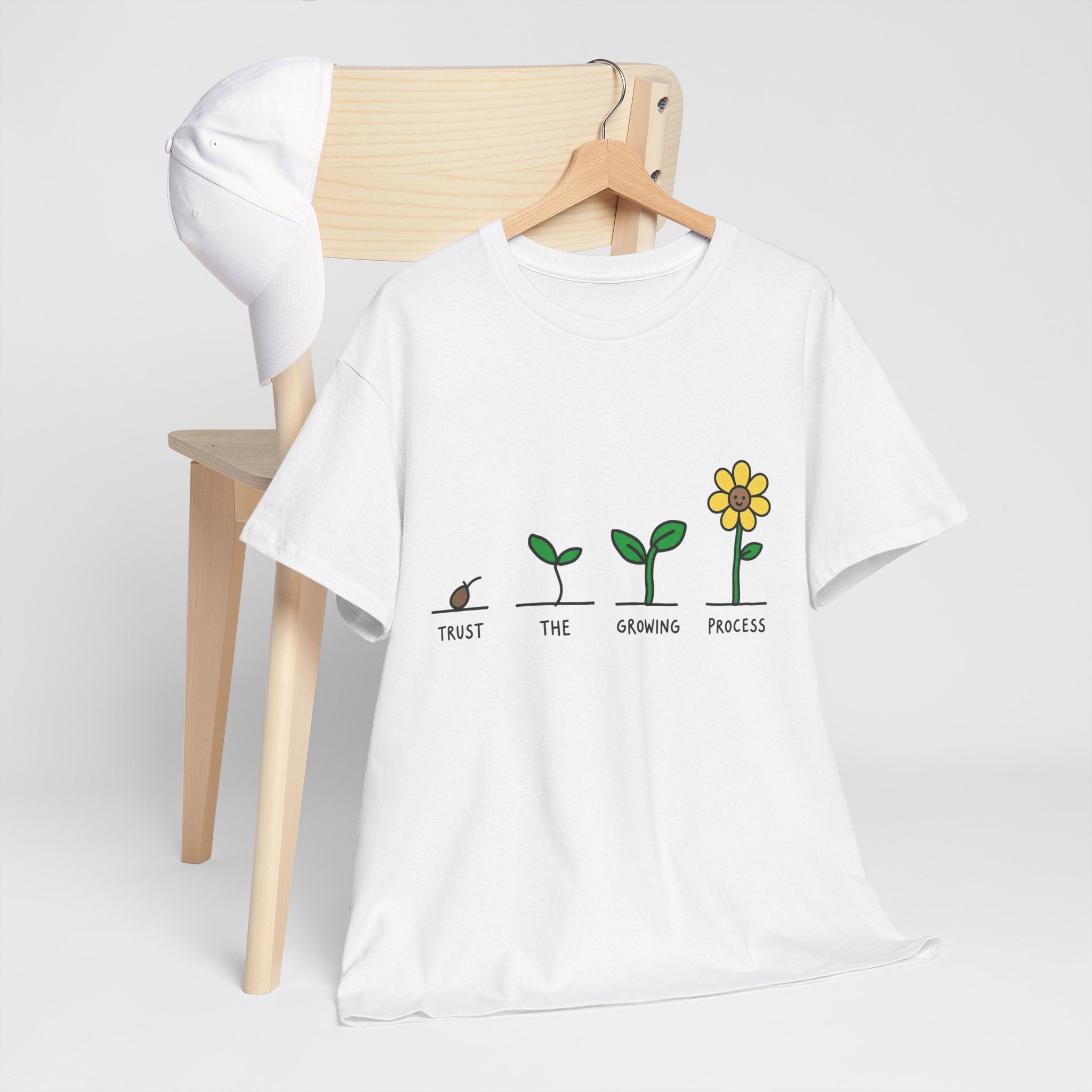 White T-shirt on hanger with sprout-to-flower graphic and message text across the chest