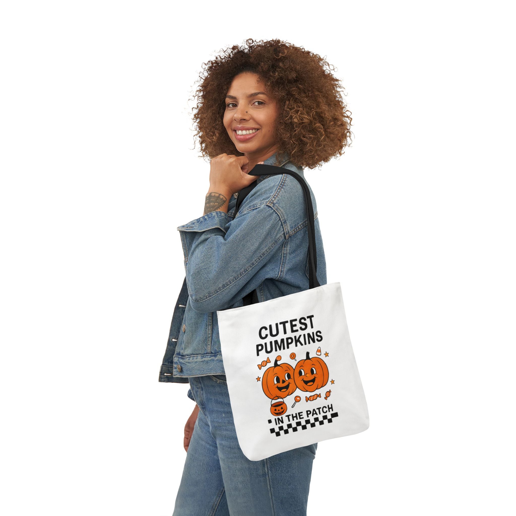 Canvas tote with black handles and pumpkin text 'CUTEST PUMPKINS IN THE PATCH', carried on shoulder.